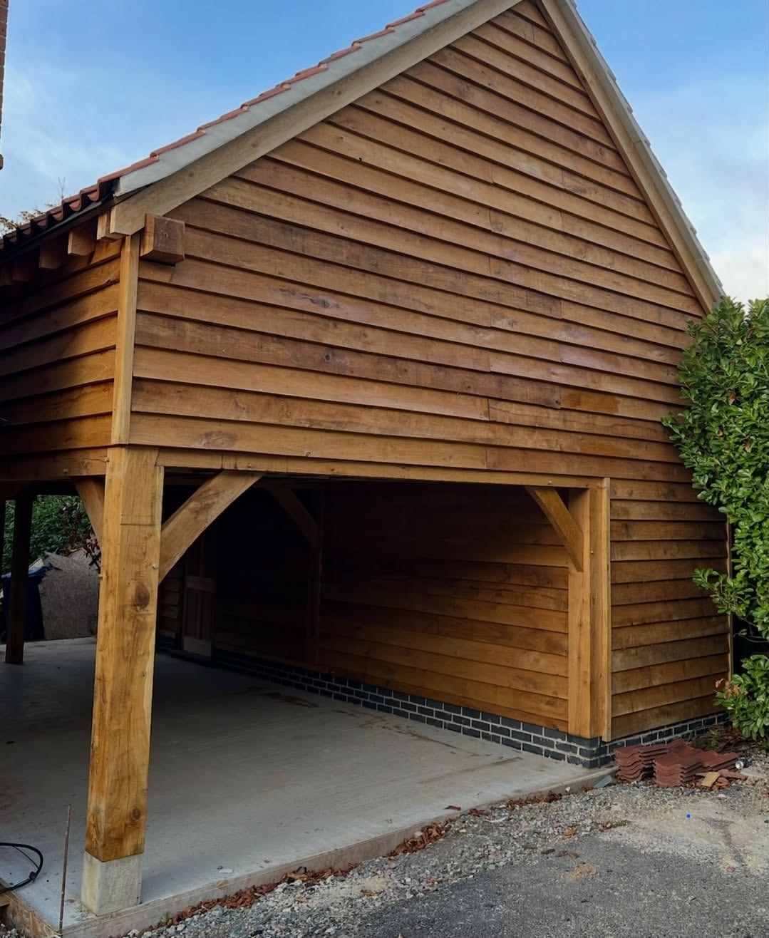 Two-bay oak frame with feather-edge boarding under a clay tile roof