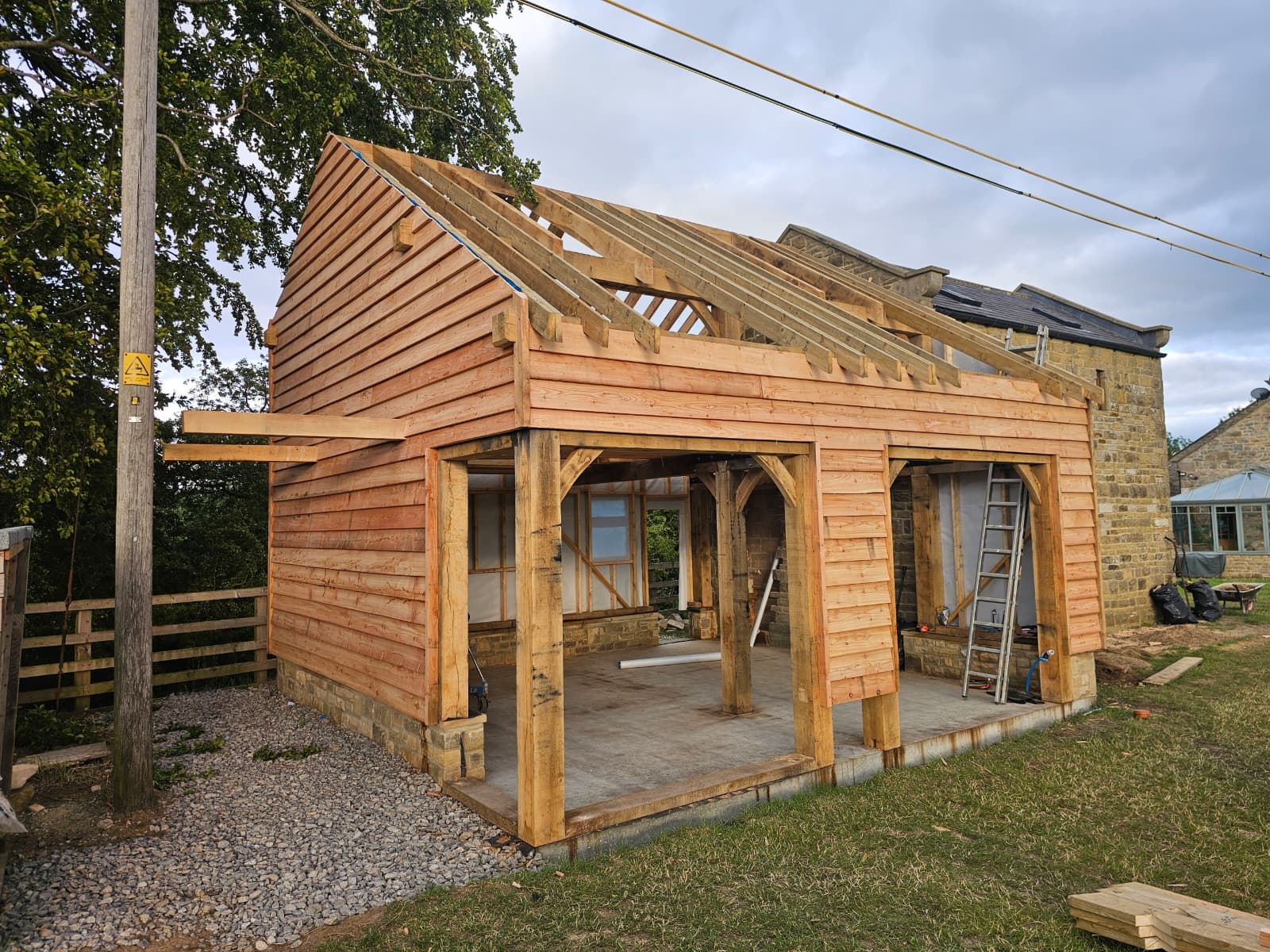 Oak frame structure during construction with cladding installation in progress