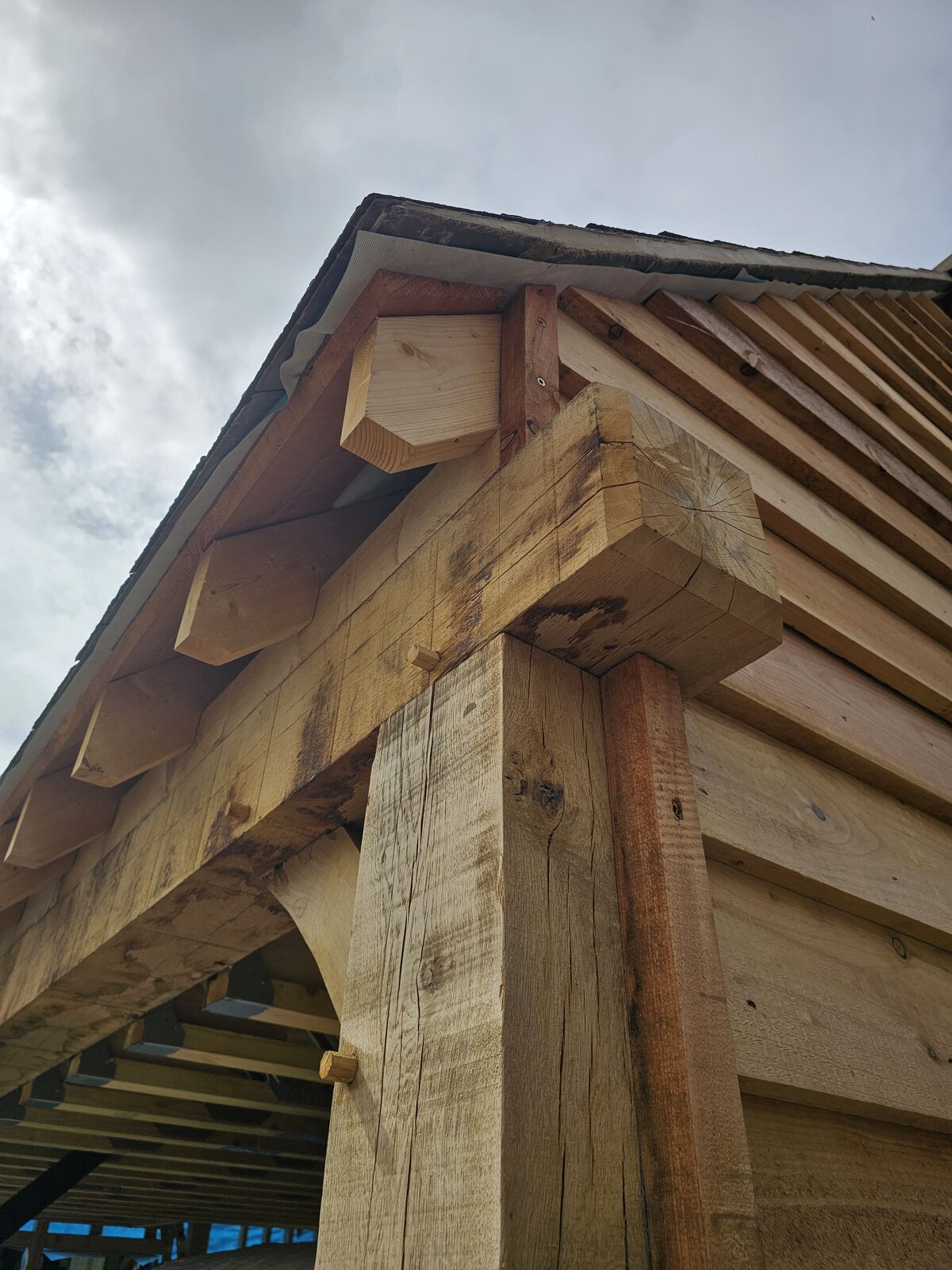 Close detail of an oak frame corner where post, wall plate and tie beam meet