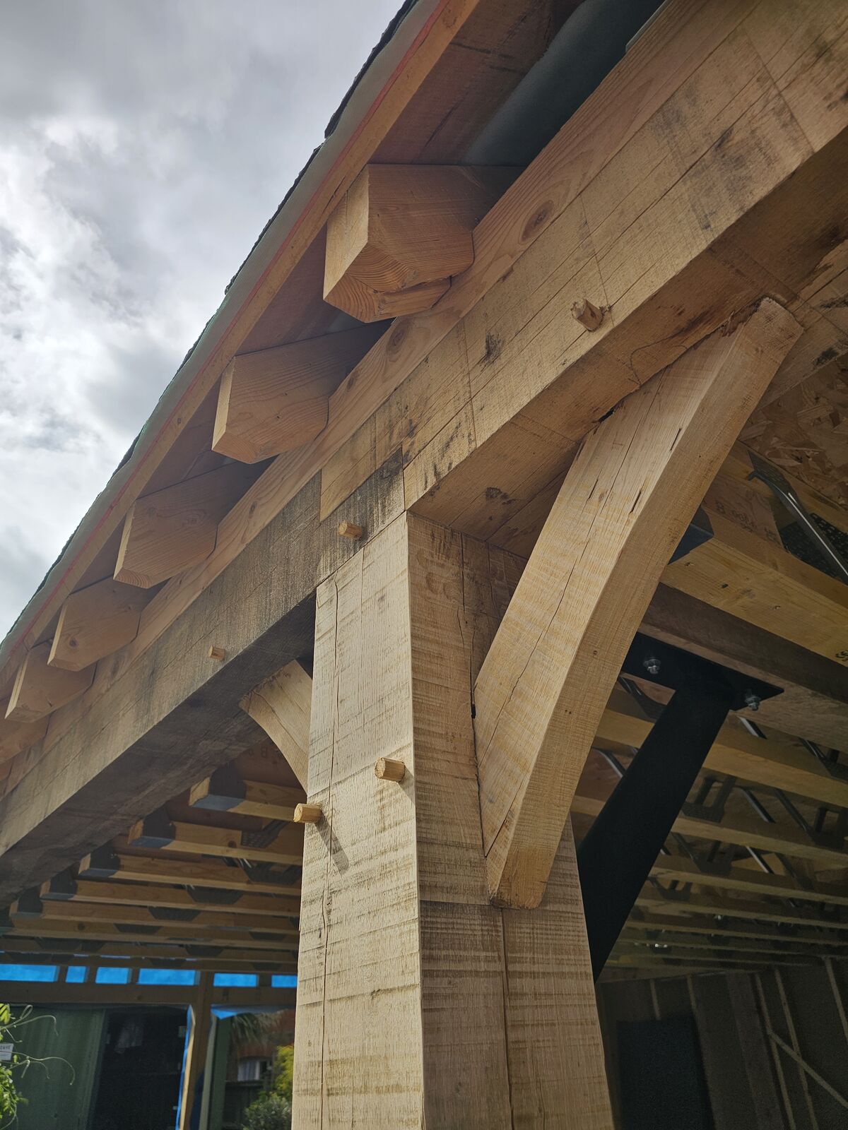 Curved oak knee brace pegged into the post and tie beam with mortise and tenon joints