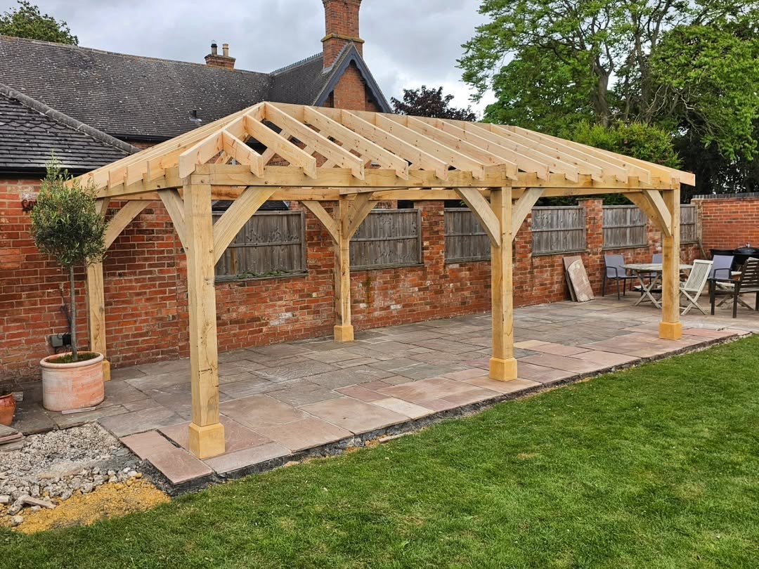 Hand-built oak pergola over a patio in a landscaped garden